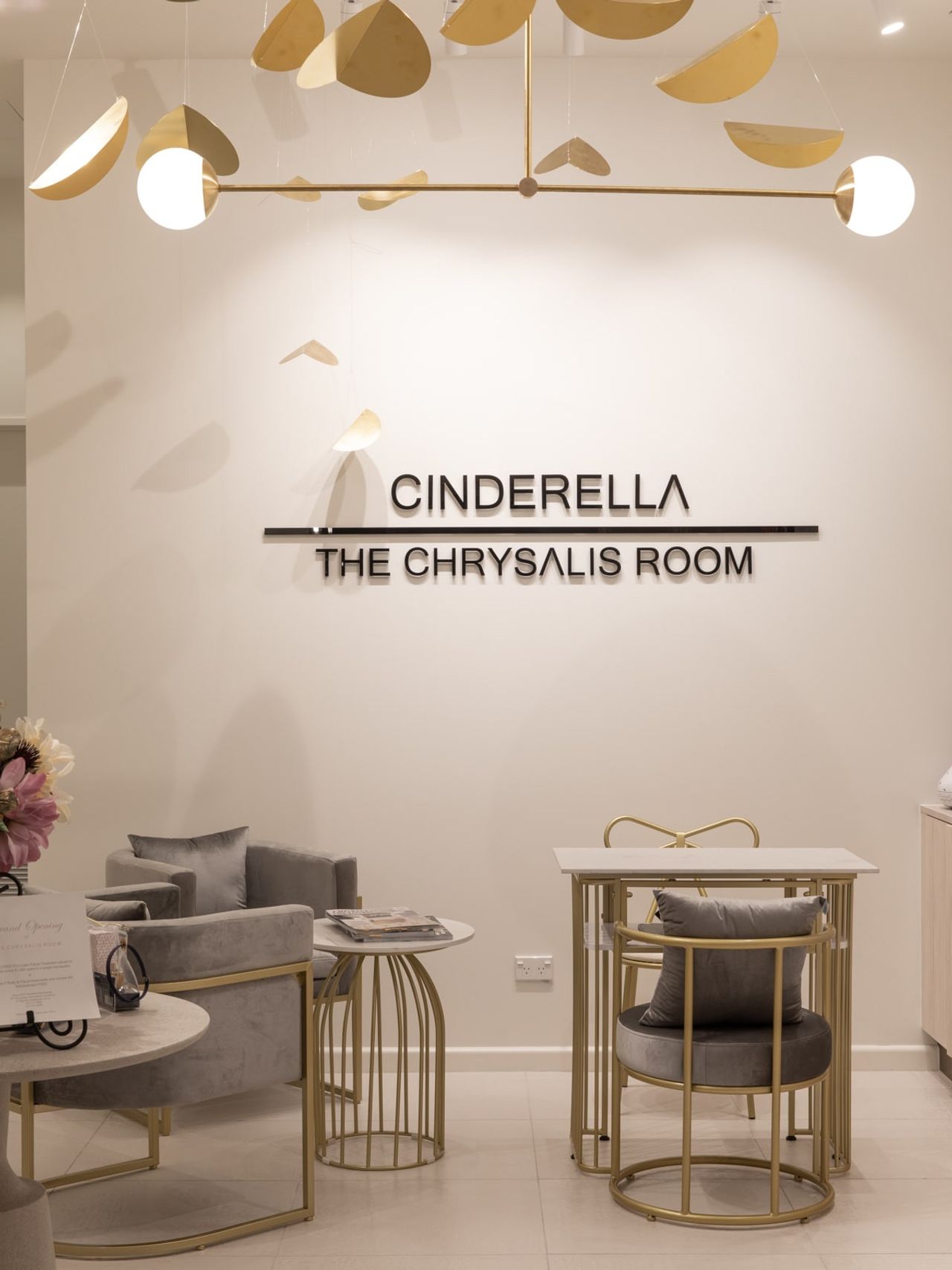 Interior of The Chrysalis Room at Cinderella Beauty, featuring plush seating and modern gold-accented decor.