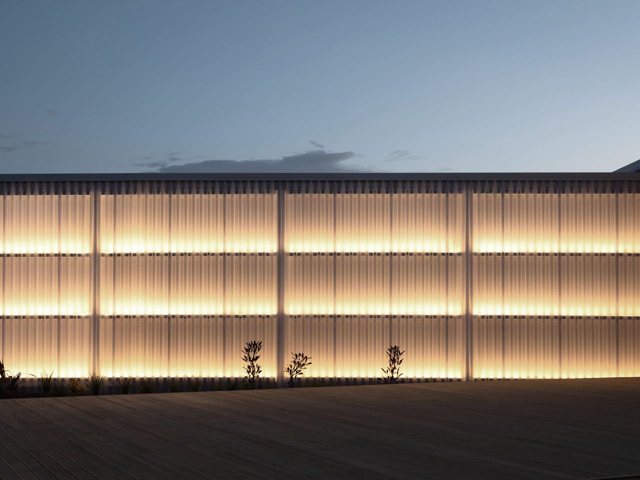 Close-up view of the illuminated facade at Fields Cafe by OKLA, highlighting modern architectural design with sleek, glowing panels in a New Zealand hospitality setting.