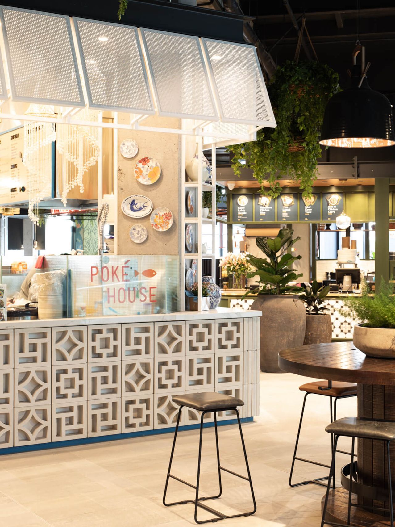 Poke House restaurant interior at Westfield Mall, showcasing patterned counters, decorative plates, greenery accents, and stylish seating. A modern hospitality design blending functionality and aesthetic in Auckland.