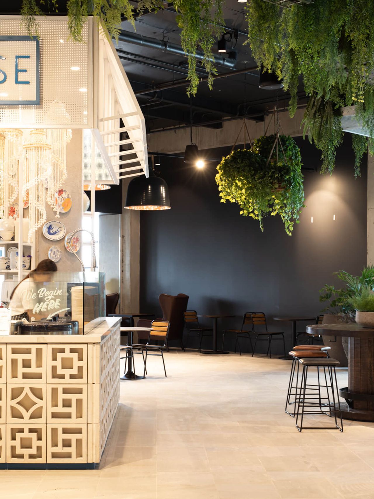 Poke House restaurant interior at Westfield Mall, highlighting patterned counters, hanging greenery, sleek black accents, and modern seating. A stylish and inviting hospitality space in Auckland.