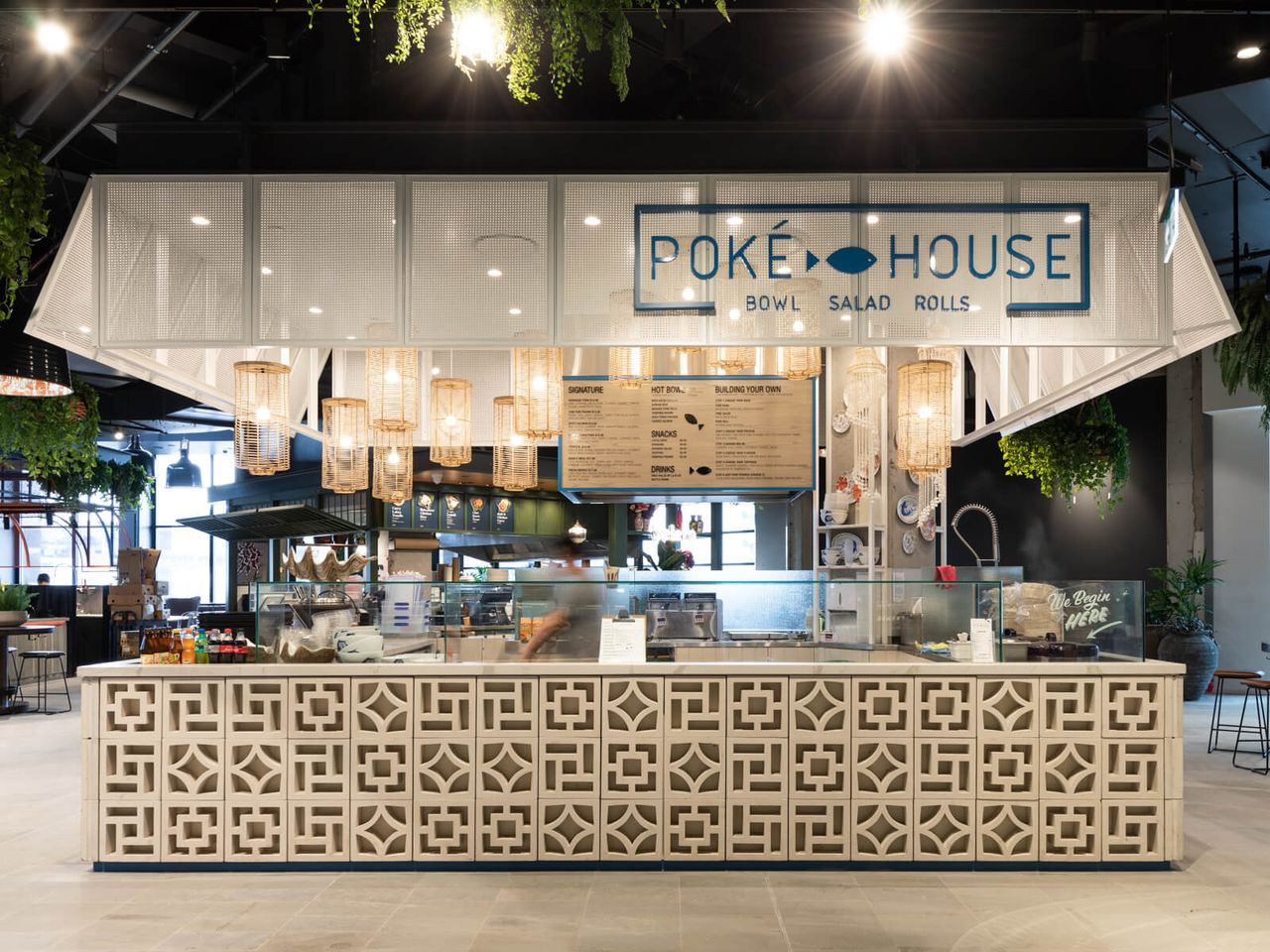 Front view of Poke House restaurant in Westfield Mall, featuring a modern hospitality design with intricate patterned counters, warm pendant lighting, and a clean, open-concept layout. A standout example of restaurant interior design in Auckland.