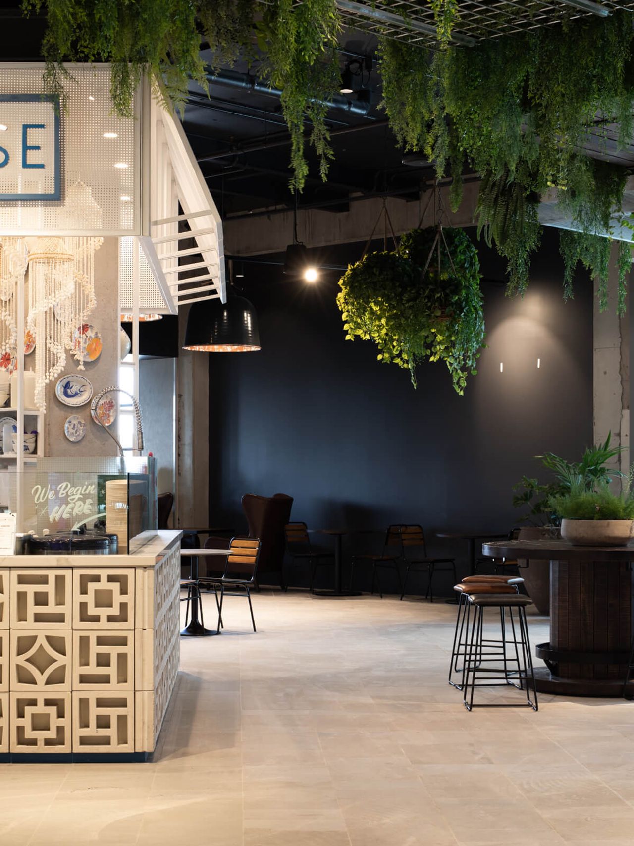 Elegant corner of Poke House restaurant at Westfield Mall, featuring intricate patterned counters, hanging greenery, and modern seating in a minimalist hospitality design setting in Auckland.